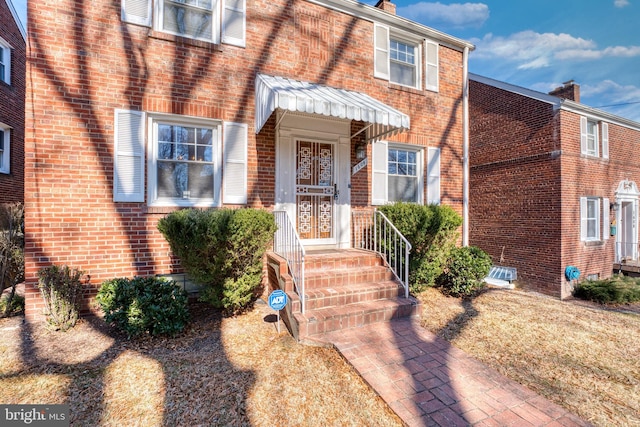 view of exterior entry featuring brick siding