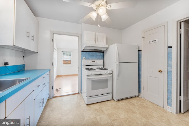 kitchen with under cabinet range hood, white appliances, a sink, white cabinets, and light countertops