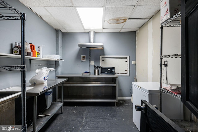 kitchen with a paneled ceiling and baseboards