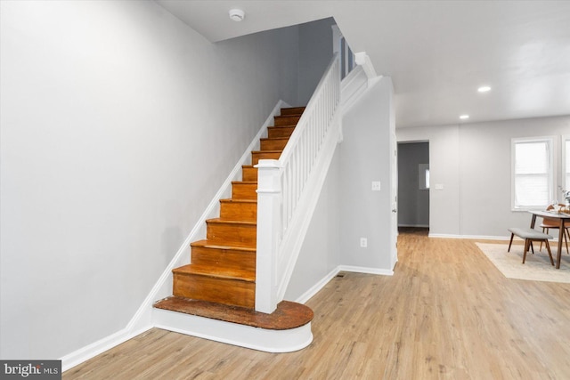 stairway featuring recessed lighting, wood finished floors, and baseboards