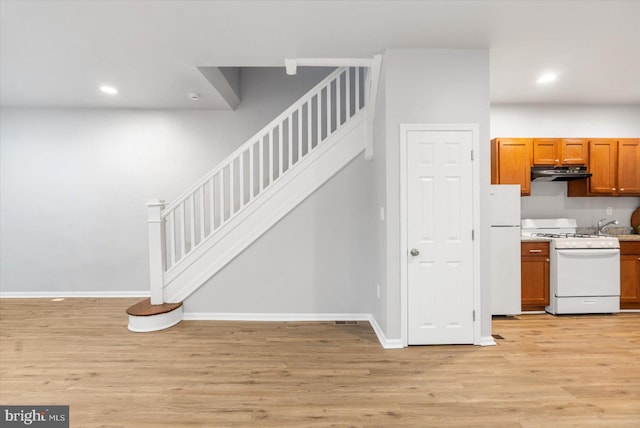 stairs with baseboards, wood finished floors, and recessed lighting