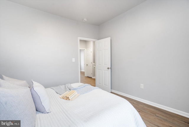 bedroom featuring baseboards and wood finished floors