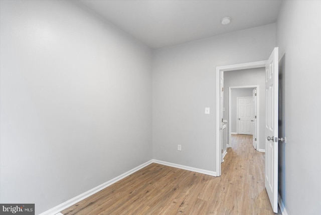 unfurnished bedroom with light wood-style flooring and baseboards