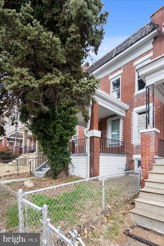 view of front facade with fence private yard and brick siding