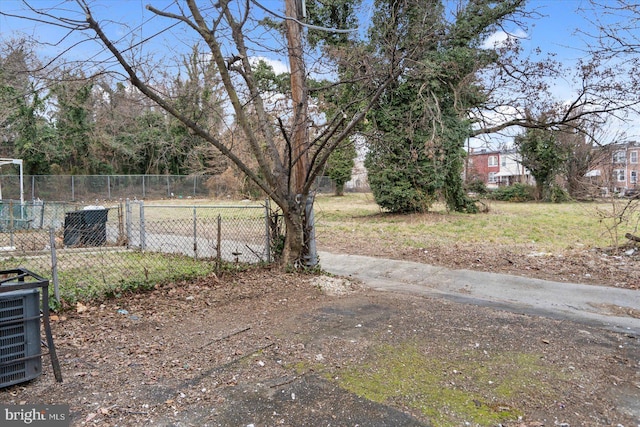 view of yard with central AC unit and fence