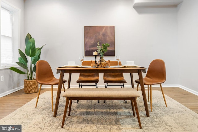 dining area with baseboards and wood finished floors