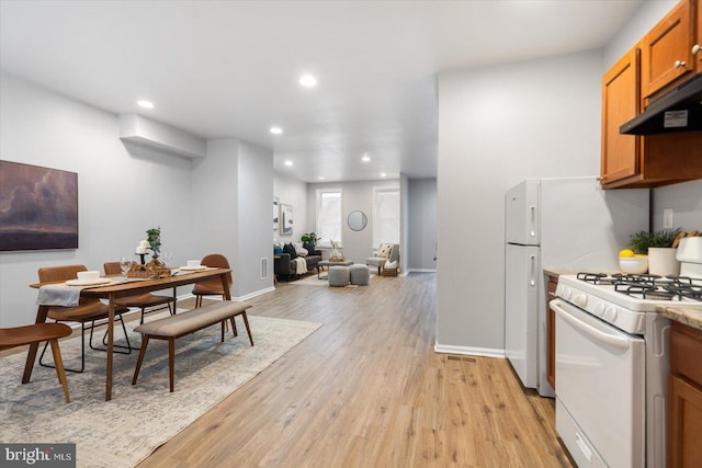 kitchen featuring under cabinet range hood, light wood finished floors, recessed lighting, and white range with gas cooktop