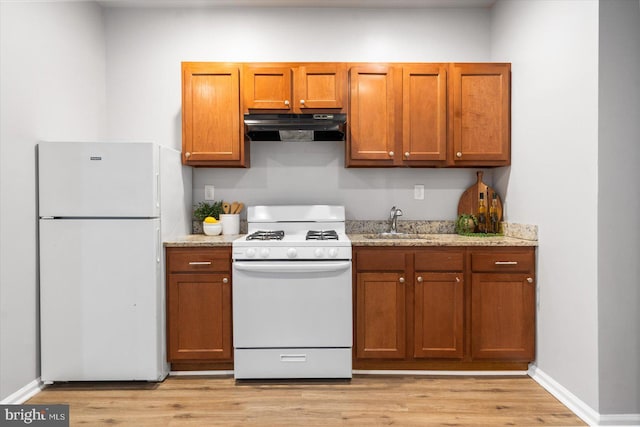 kitchen featuring light wood-style floors, white appliances, a sink, and under cabinet range hood