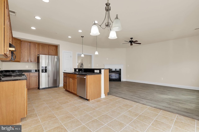 kitchen with dark countertops, under cabinet range hood, visible vents, and stainless steel appliances