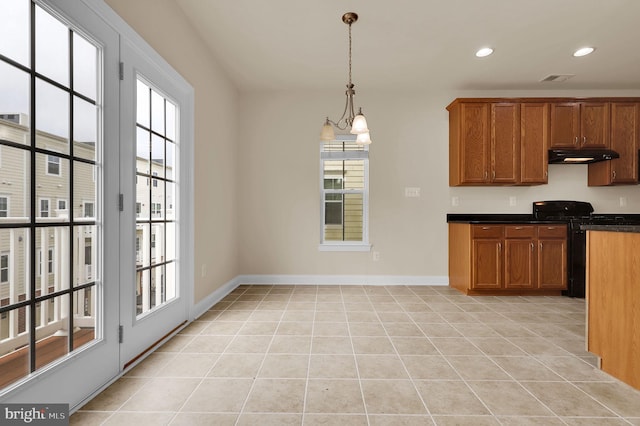 kitchen featuring dark countertops, brown cabinets, black gas range oven, and under cabinet range hood