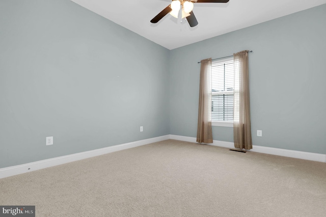 empty room featuring baseboards, visible vents, ceiling fan, and light colored carpet