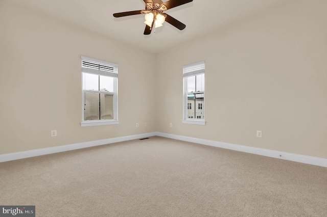 empty room with ceiling fan, visible vents, baseboards, and light colored carpet