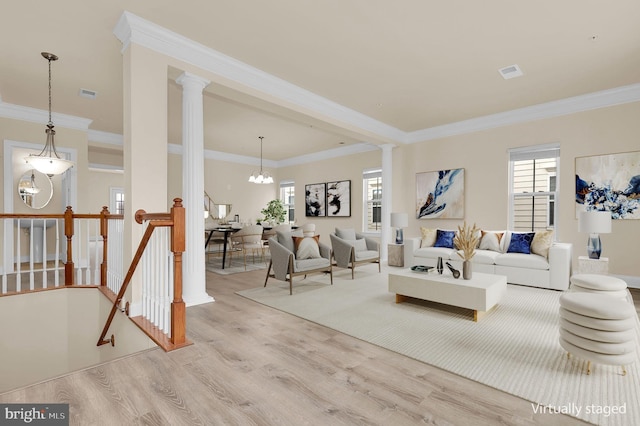 living room featuring ornamental molding, visible vents, ornate columns, and wood finished floors