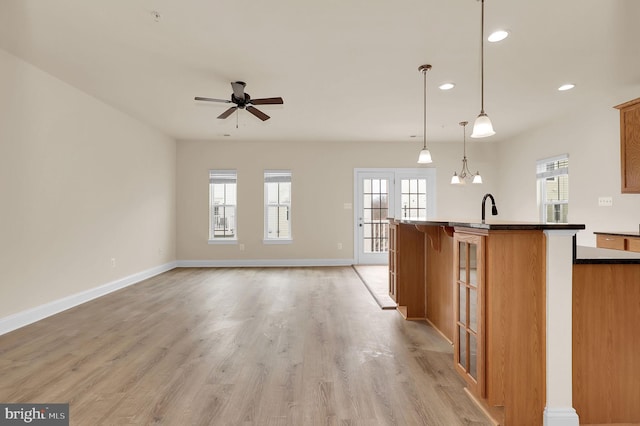 kitchen with brown cabinetry, a healthy amount of sunlight, and light wood-style floors