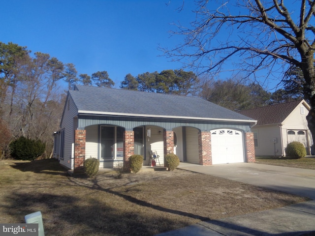 view of front facade featuring brick siding, roof with shingles, a garage, driveway, and a front lawn