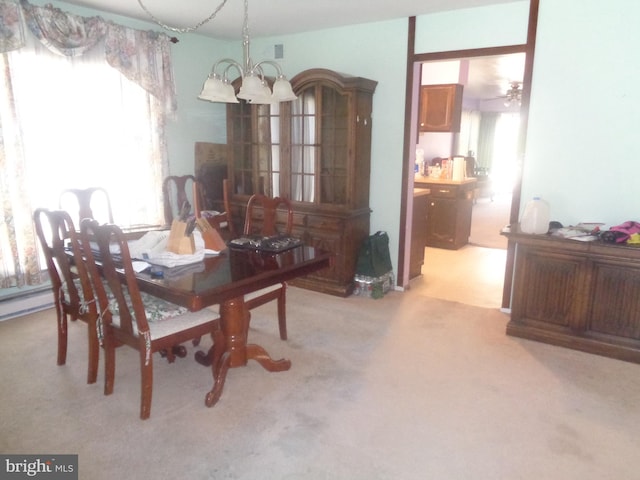 dining space featuring light colored carpet and an inviting chandelier