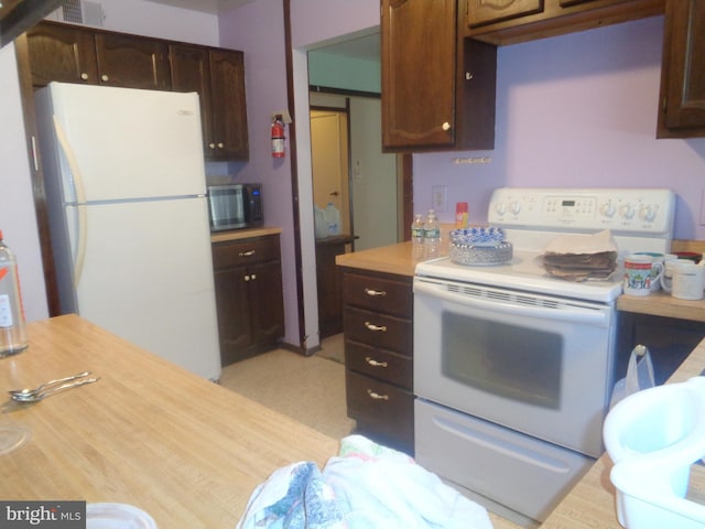 kitchen featuring visible vents, light countertops, white appliances, and dark brown cabinetry