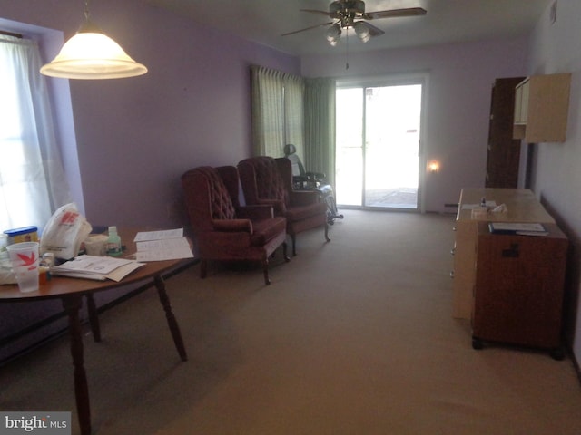 carpeted living area with ceiling fan