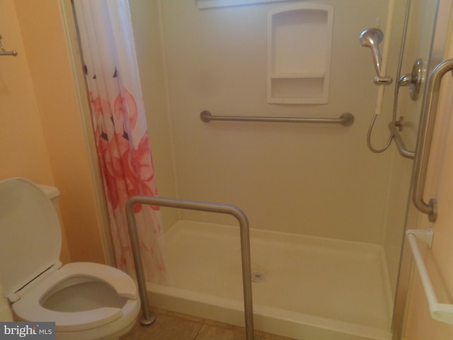 full bath with tile patterned flooring, a shower stall, and toilet