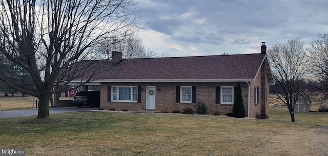 view of front facade with brick siding, a chimney, and a front yard