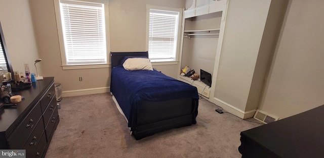 carpeted bedroom featuring visible vents, baseboards, and a closet