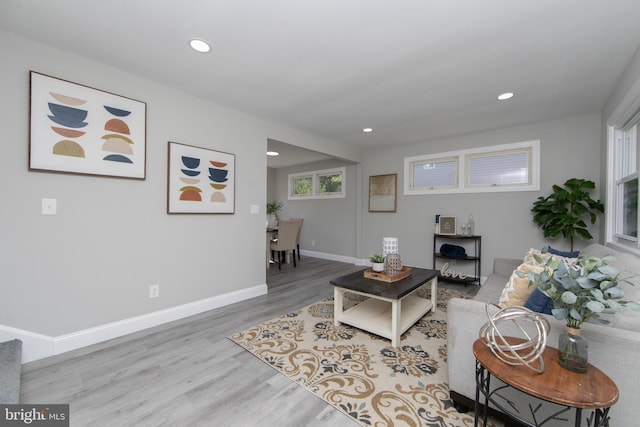 living room featuring baseboards, wood finished floors, and recessed lighting