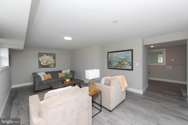 living area with baseboards and wood finished floors