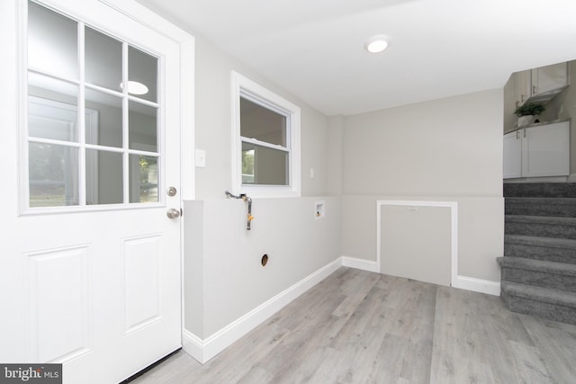 interior space featuring baseboards, laundry area, hookup for a washing machine, and light wood-style floors