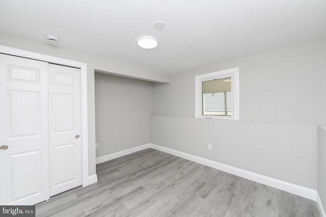 basement with light wood-style flooring and baseboards