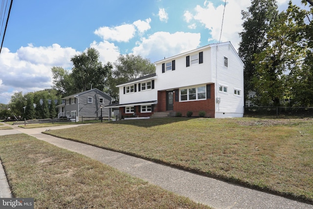 split level home featuring crawl space, brick siding, fence, and a front lawn