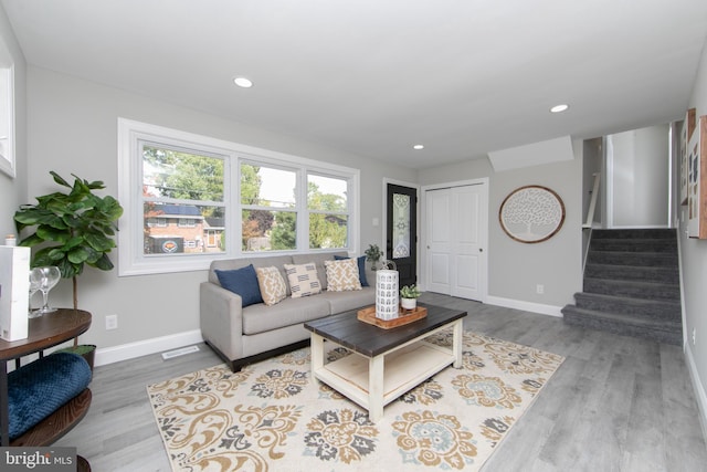 living room featuring stairway, recessed lighting, wood finished floors, and baseboards