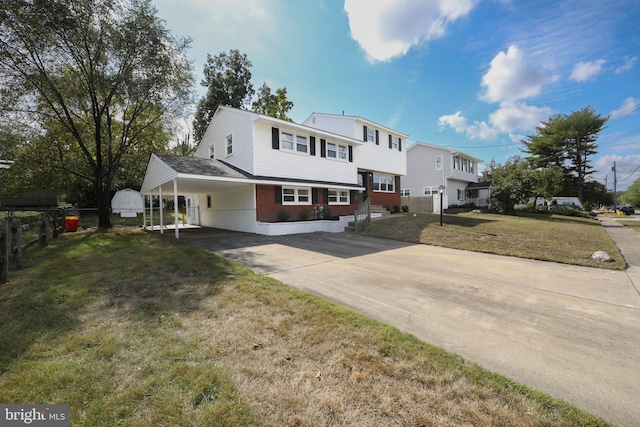 view of front of property featuring a front yard, an attached carport, concrete driveway, and brick siding