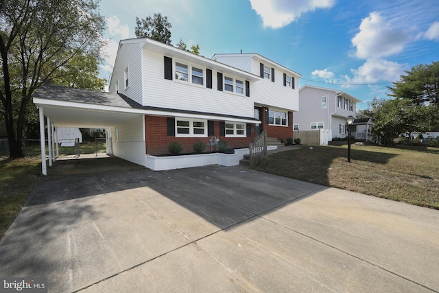 view of front of home with an attached carport, brick siding, driveway, and a front yard