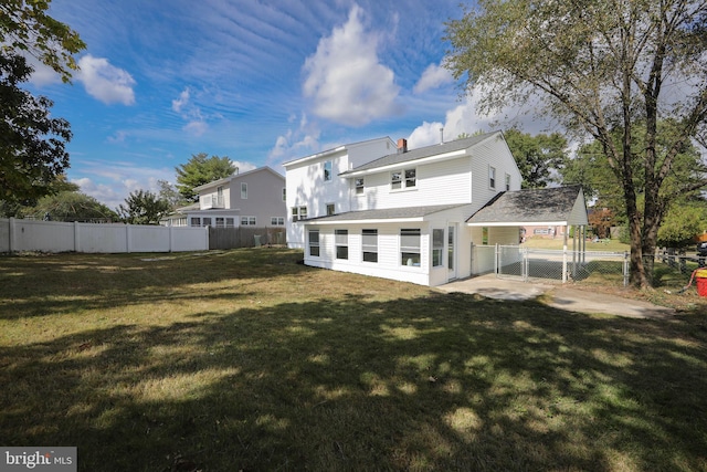 back of house with a gate, a fenced backyard, and a yard