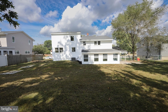 back of property with a yard, central AC, and fence