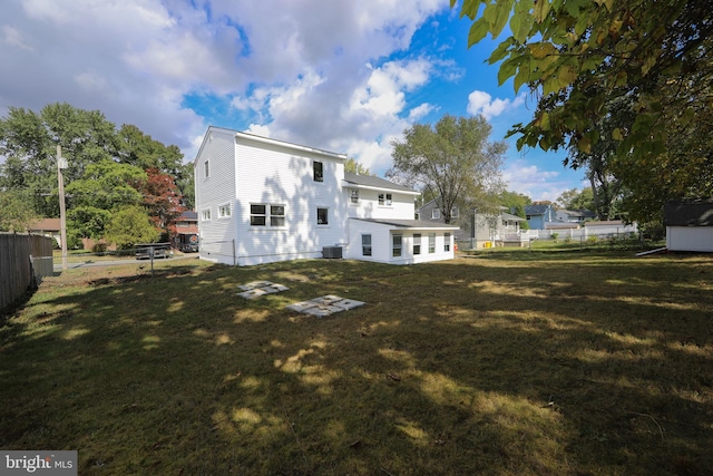 rear view of property featuring a fenced backyard and a yard