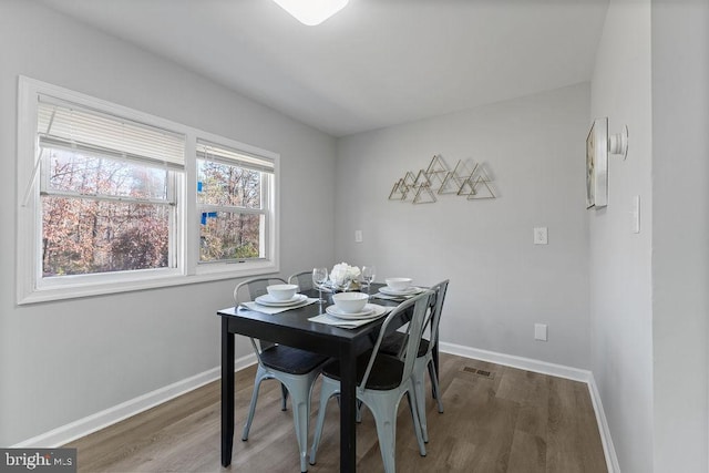 dining area with visible vents, baseboards, and wood finished floors