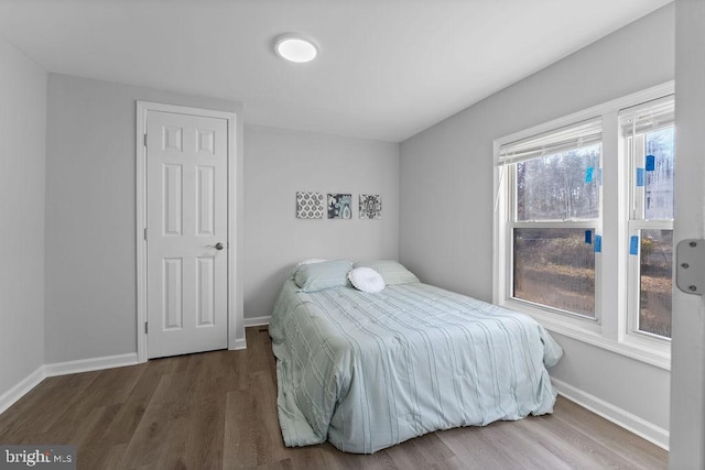 bedroom featuring wood finished floors and baseboards