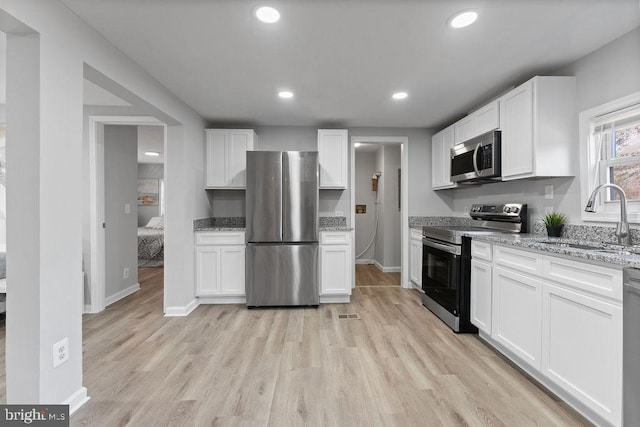 kitchen with white cabinetry, appliances with stainless steel finishes, and a sink