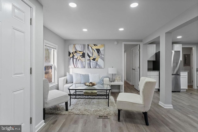 sitting room with baseboards, light wood finished floors, visible vents, and recessed lighting