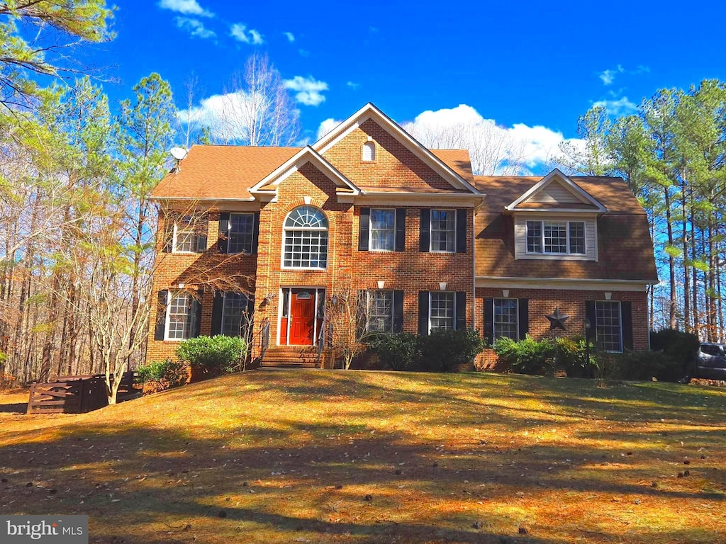 view of front of house with a front lawn and brick siding