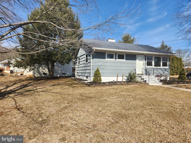 single story home with entry steps, a chimney, and a front lawn