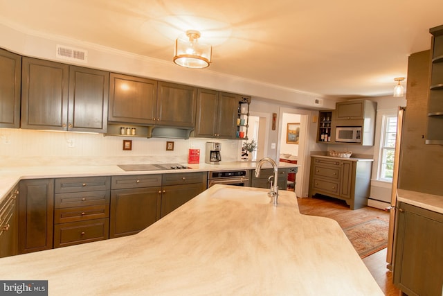 kitchen featuring open shelves, stainless steel appliances, light countertops, visible vents, and a sink