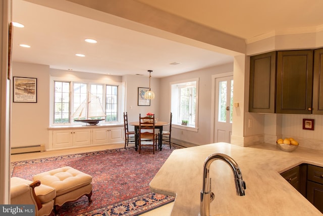 kitchen featuring a baseboard radiator, decorative light fixtures, light countertops, a sink, and recessed lighting