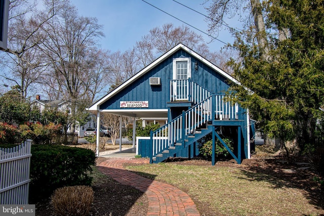 rear view of house with fence and stairs