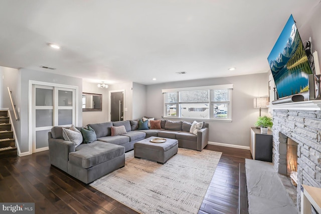 living room with baseboards, dark wood-style floors, stairs, a fireplace, and recessed lighting