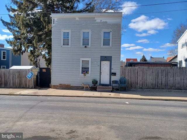 view of front facade with entry steps and fence