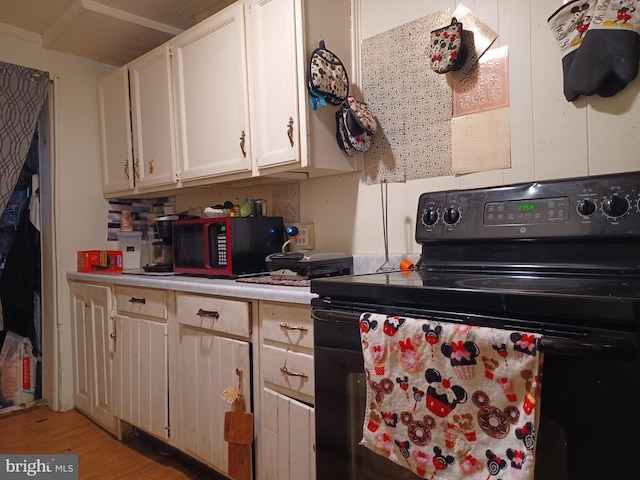 kitchen with light wood-style floors, electric range, white cabinetry, and light countertops