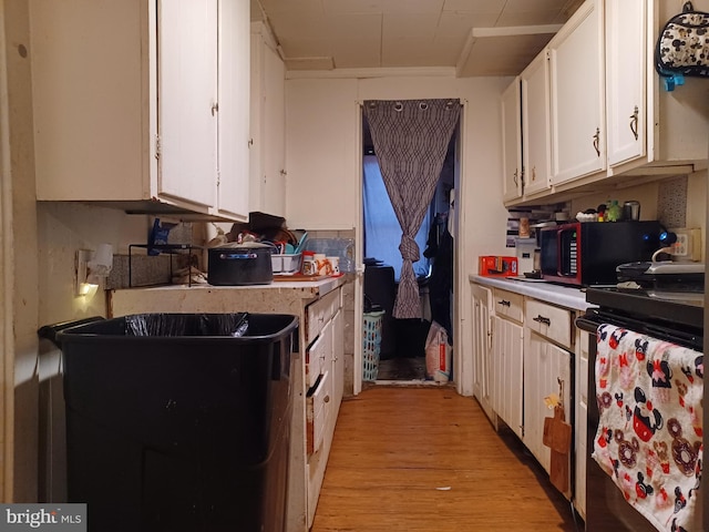 kitchen featuring light countertops, white cabinetry, and light wood finished floors