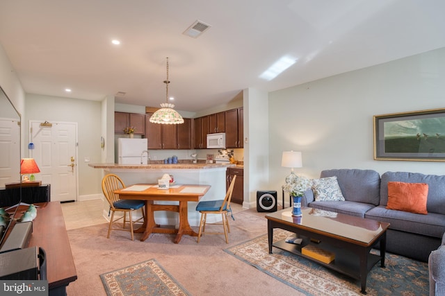 living room featuring light colored carpet, visible vents, baseboards, and recessed lighting